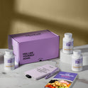 A product bundle display for GleeFull Supplements on a marble surface against a yellow background. The layout includes a large purple shipping box featuring the slogan 'FEEL LIKE YOURSELF AGAIN.', three white bottles of Adrenal Restore, a purple branded pen, a matching notepad that reads 'REMINDERS WHEN I'M HAVING A MENOPAUSE MOMENT', and a recipe booklet titled 'THE MENOPAUSE Recipes'