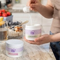 GleeFull Hormonelyte and Meno Creatine jars on a marble countertop in a kitchen setting.