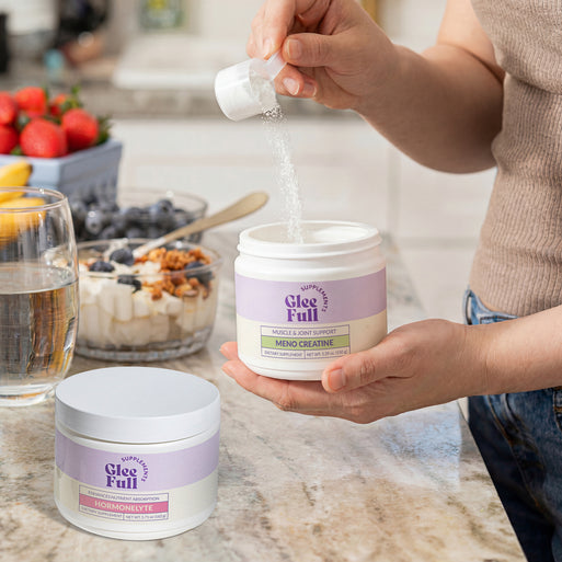 GleeFull Hormonelyte and Meno Creatine jars on a marble countertop in a kitchen setting.